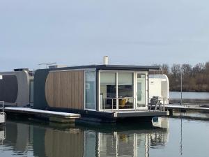 马斯特里赫特Houseboat Trinidad的水面上的一个小房子