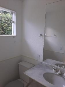 une salle de bain avec toilettes, lavabo et miroir dans l'établissement Casa Porto Frade Angra dos Reis, à Angra dos Reis