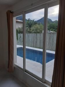 Elle offre une vue sur la piscine depuis sa fenêtre. dans l'établissement Casa Porto Frade Angra dos Reis, à Angra dos Reis