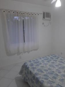 - une chambre avec un lit et un rideau blanc dans l'établissement Casa Porto Frade Angra dos Reis, à Angra dos Reis
