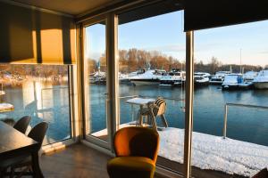 een kamer met ramen met uitzicht op een jachthaven bij Houseboat Trinidad in Maastricht