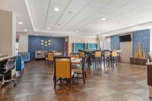 a dining room with tables and chairs and blue walls at Best Western Plus Fairburn Atlanta Southwest in Fairburn