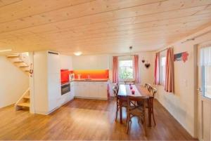 eine Küche mit einem Tisch und Stühlen im Zimmer in der Unterkunft Bauernhof Fendrig  - neue Wohnung - b48546 in Haslen