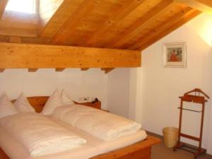 Casa Capricorn Nr 22 - b48498 في مالويه: سرير في غرفة ذات سقف خشبي