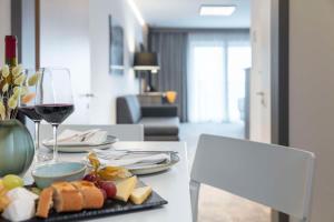 una tavola con un piatto di cibo e un bicchiere di vino di Park Inn By Radisson Wismar a Wismar