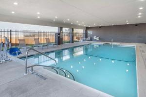 a large swimming pool in a hotel with chairs at Best Western Plus Stephenville Inn in Stephenville