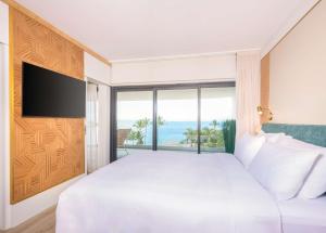 サン・ドニにあるRadisson Hotel Saint Denis, La Reunionのベッドルーム(大きな白いベッド1台、大きな窓付)