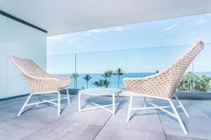 2 sillas y una mesa en una habitación con ventanas en Radisson Hotel Saint Denis, La Reunion en Saint-Denis