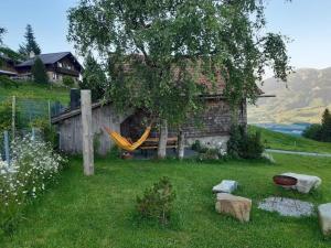 a hammock in a yard next to a house at Alphütte Chilchschwand - b48558 in Stalden