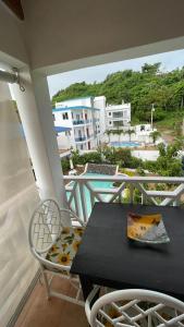 una mesa y sillas en un balcón con vistas en Tropical Doña Mayra apartahotel en Las Terrenas