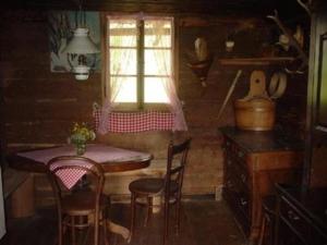 cocina con mesa, sillas y ventana en Alphütte Chilchschwand - b48558, en Stalden