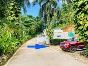 um carro vermelho estacionado em frente a uma palmeira em Cozy Studio in Private Villa em Las Terrenas
