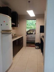 eine Küche mit einem Kühlschrank und einem Auto darin in der Unterkunft Cabaña Holly Water in Cerro Azul