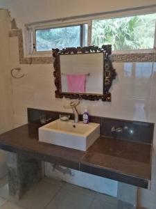 y baño con lavabo y espejo. en Cabaña Holly Water, en Cerro Azul