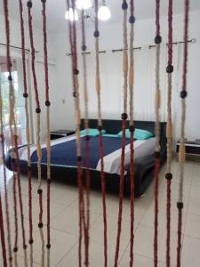 Ce lit se trouve dans un dortoir doté de poteaux en bois. dans l'établissement Cabaña Holly Water, à Cerro Azul