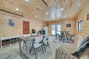 een woonkamer met tafels en stoelen in een blokhut bij Roscommon Cabin, Walk to Higgins Lake in Roscommon