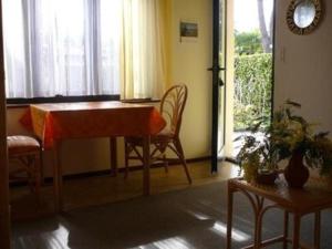 ein Wohnzimmer mit einem Tisch, Stühlen und einem Fenster in der Unterkunft Casa Adelizia - Erdgeschoss - b48561 in Ascona