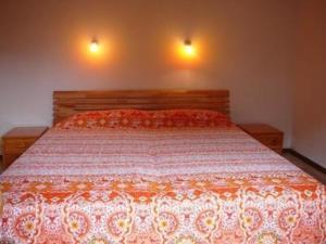 ein Bett in einem Schlafzimmer mit zwei Lichtern an der Wand in der Unterkunft Casa Adelizia - Erdgeschoss - b48561 in Ascona