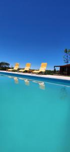 a row of chairs sitting in a swimming pool at Cabañas Potrero de Marquez in Potrero de Garay