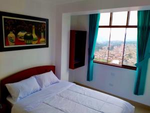 a bedroom with a bed and two windows at HOSTAL EL MIRADOR CHACHAPOYAS in Chachapoyas