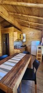 eine Küche mit einem großen Holztisch in einer Hütte in der Unterkunft Cabañas Potrero de Marquez in Potrero de Garay