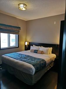 a large bed in a bedroom with a window at Sweet Condo Canmore GR：） in Canmore