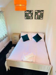 a bedroom with a white bed with blue pillows at Your Staycation in Bristol