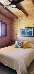 ein Schlafzimmer mit einem Bett in einer Holzhütte in der Unterkunft Cabañas Potrero de Marquez in Potrero de Garay