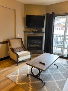 a living room with a tv and a fireplace at Sweet Condo Canmore GR：） in Canmore