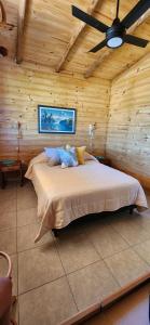 ein Schlafzimmer mit einem Bett in einer Holzhütte in der Unterkunft Cabañas Potrero de Marquez in Potrero de Garay