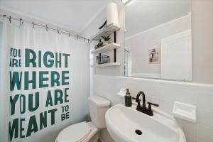 uma casa de banho com um WC branco e um lavatório. em GameTime Hide Out Vibes em Detroit