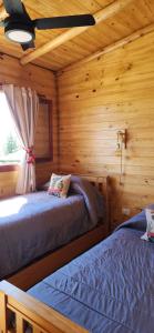 a bedroom with two beds in a log cabin at Cabañas Potrero de Marquez in Potrero de Garay