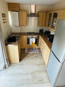 a small kitchen with wooden cabinets and a refrigerator at Your Staycation in Bristol
