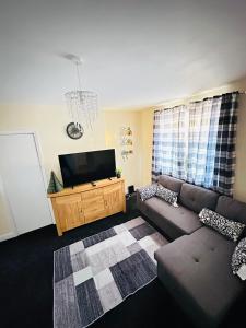 a living room with a couch and a flat screen tv at Your Staycation in Bristol