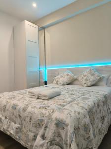 una camera da letto con un letto con un piumone e cuscini bianchi di HABITACIÓN EN VIVIENDA CENTRICA BILBAo 18 a Bilbao