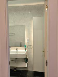 bagno con lavandino bianco e specchio di HABITACIÓN EN VIVIENDA CENTRICA BILBAo 18 a Bilbao