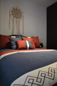1 cama con almohadas de color naranja y azul en un dormitorio en Suite Zen, en Guatemala