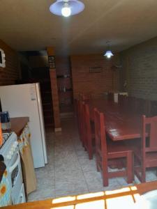 een keuken met een tafel en stoelen en een koelkast bij la casona in Mina Clavero