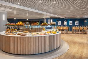 a cafeteria with a buffet of food on a table at Crowne Plaza Milan Linate by IHG in San Donato Milanese