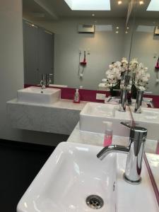 a bathroom with three sinks and a mirror at YHA Nelson in Nelson