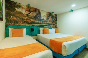 duas camas num quarto com um quadro na parede em Hotel Casa Antigua em Bogotá