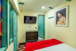 a bedroom with a bed and a flat screen tv at Hotel Casa Antigua in Bogotá