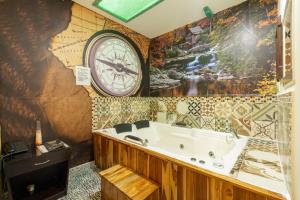 baño con bañera y reloj en la pared en Hotel Casa Antigua, en Bogotá