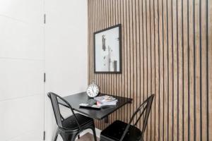 a table and chairs in a room with a wall at Luxury Entire Apartment in Cowley