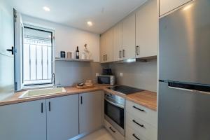 a kitchen with white cabinets and a sink and a window at Manifesto Seaview Apartment II in Kalymnos