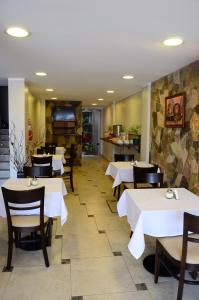 a dining room with white tables and chairs at Munay Ledesma in Libertador General San Martín