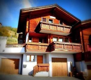 a large house with balconies on the side of it at Chalet Angelika - b48583 in Albinen