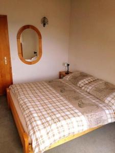 a bedroom with a bed and a round mirror at Chalet Angelika - b48583 in Albinen