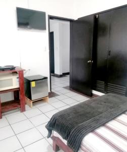 a bedroom with a bed and a desk and a sink at Habitación Mar in Veracruz