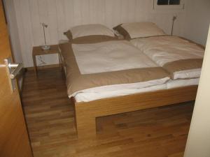 uma cama grande num quarto com piso em madeira em Bim Bühlmättli 4 Bett Wohnung - b48629 em Grindelwald